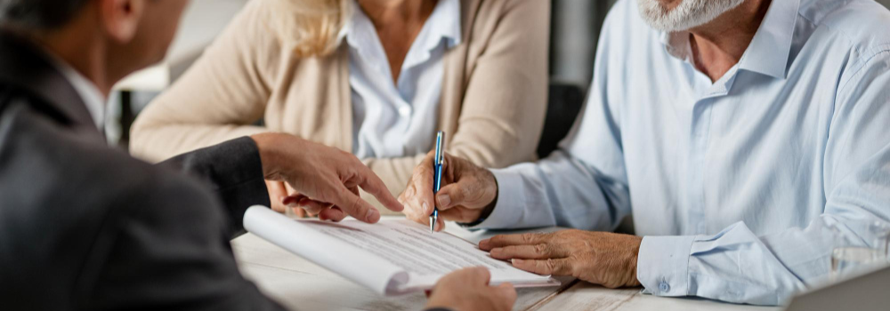 Mature couple signing legal documents. Image by Drazen Zigic on Freepik